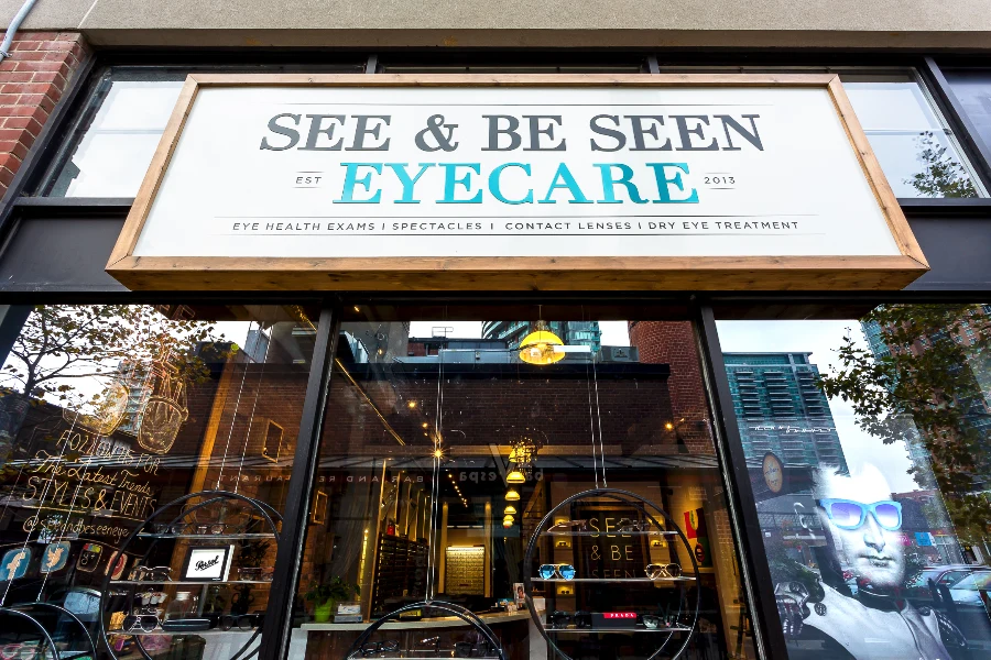 The framed storefront sign above the entrance at See & Be Seen — Liberty Village